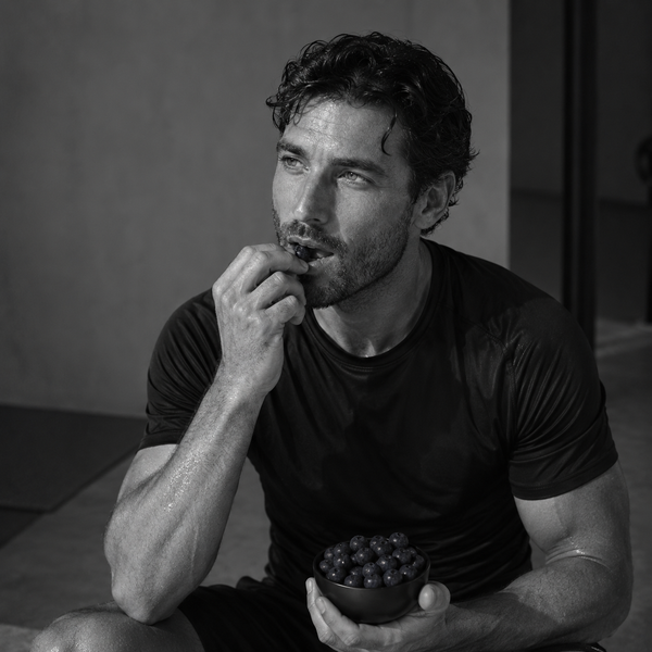 Hombre tras entrenar comiendo arándanos, ejemplo de alimentación rica en micronutrientes
