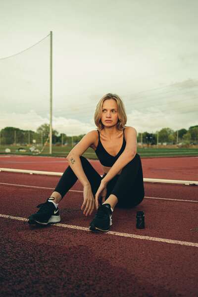 Mujer deportista con bote de ZZEN Focus en la pista de atletismo