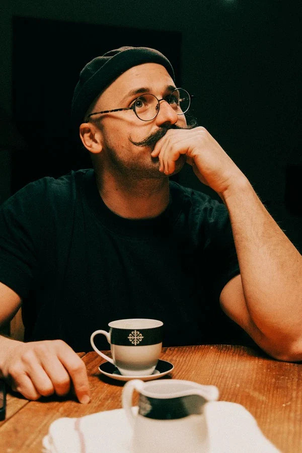 Hombre pensativo apoyado en una mesa