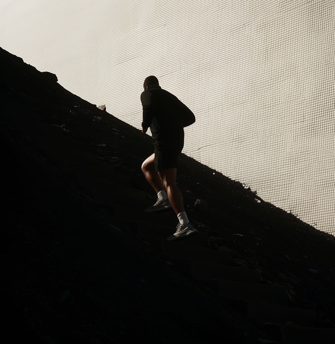 Un hombre corriendo cuesta arriba en la oscuridad