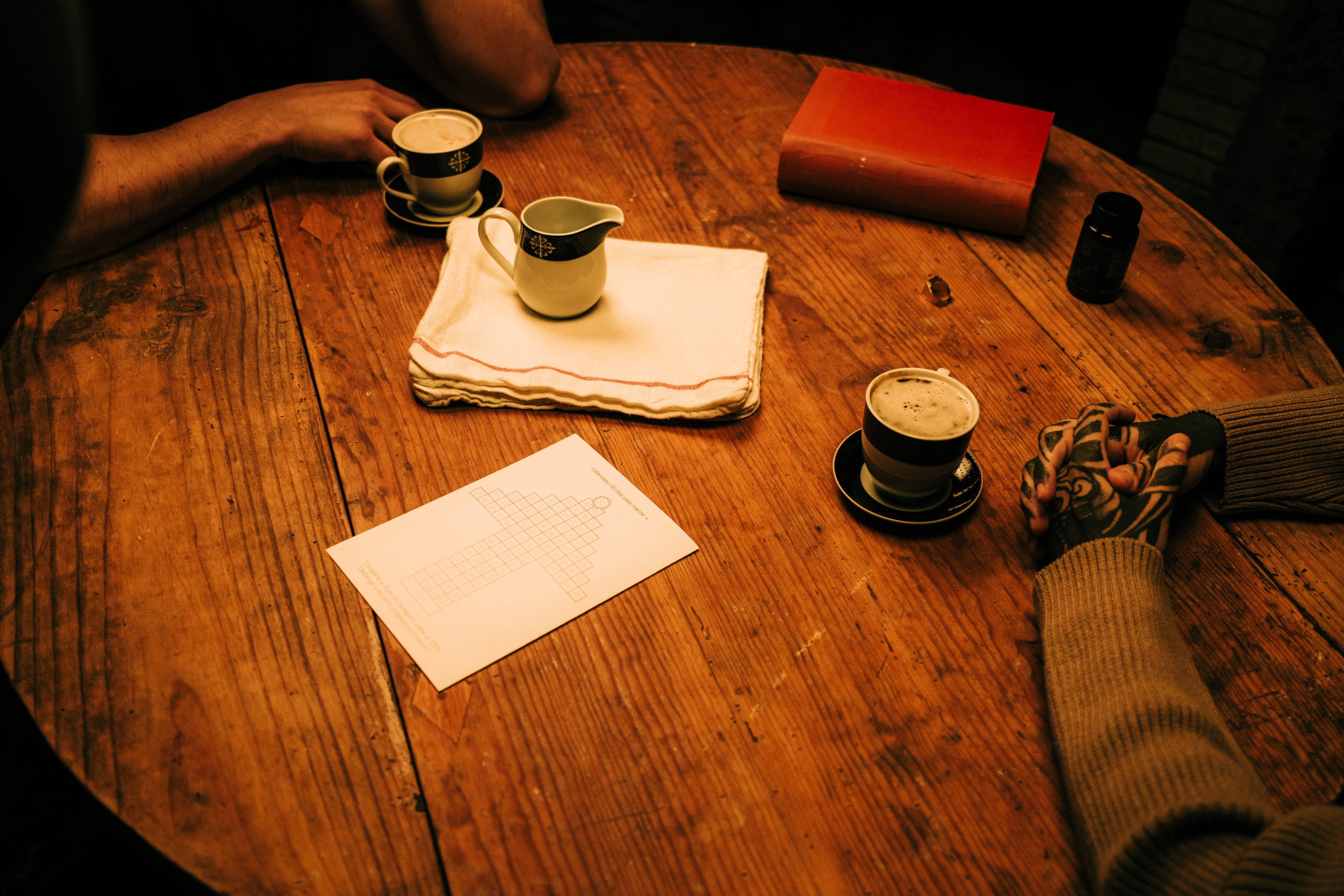 Mesa de madera con café y elementos varios