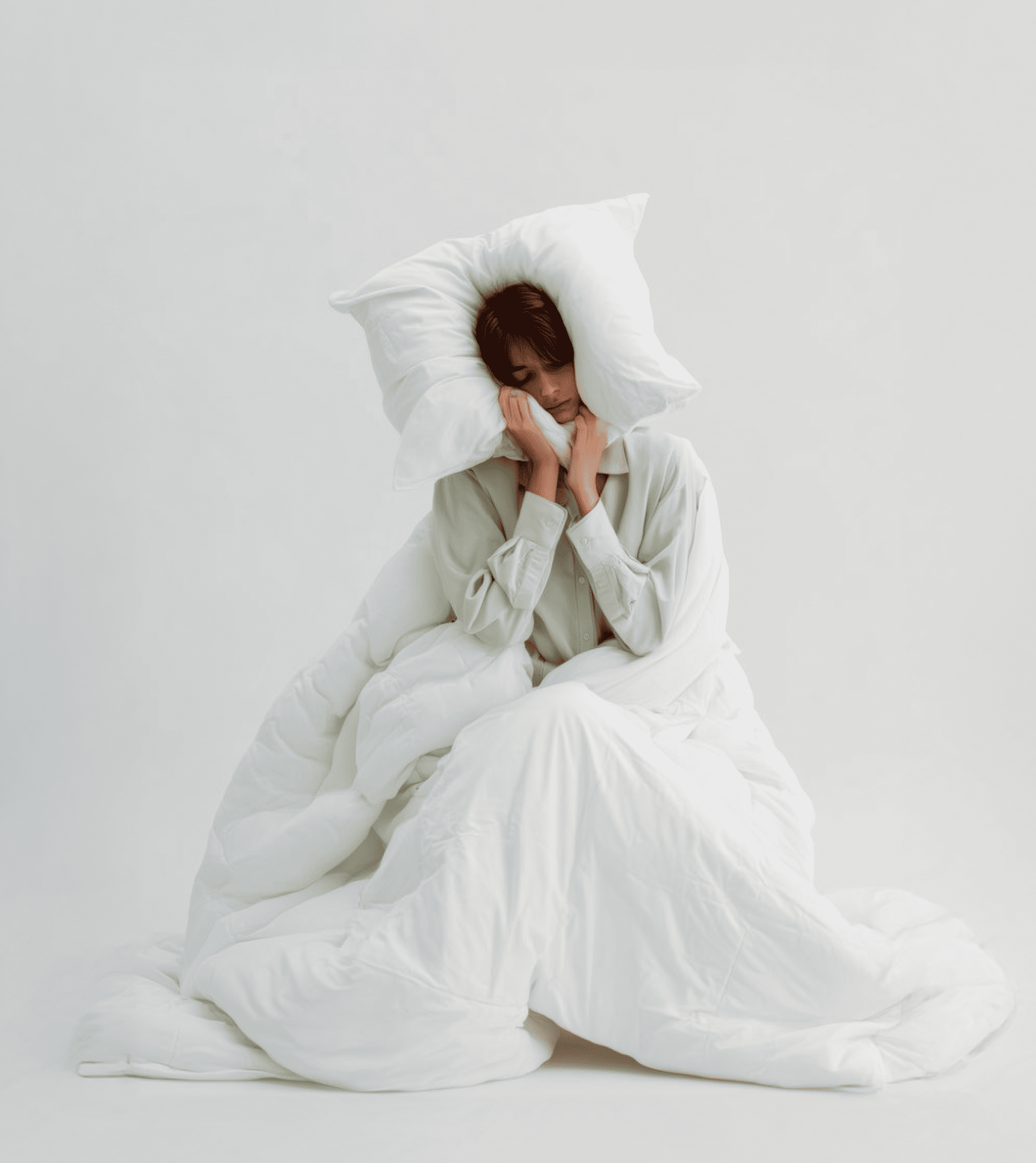 Chica durmiendo entre cojines y edredón